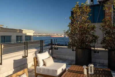 a patio with a table and a chair on a balcony at The Muradiye Luxury Apartments in Istanbul