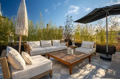 a patio with couches and a table and an umbrella at The Muradiye Luxury Apartments in Istanbul