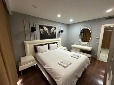 a bedroom with a large white bed and a mirror at Gold Suit - Bakırköy City Center in Istanbul
