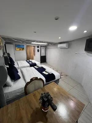 a large room with two beds and a table at Taksim Nova House hotel in Istanbul