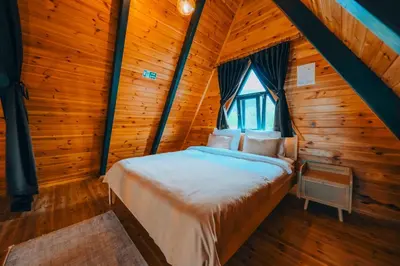 a bedroom with a bed in a log cabin at Melodi Bungalov Sapanca in Sakarya