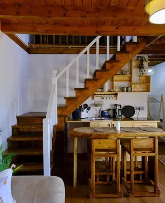 a kitchen with a wooden table and stairs at Sapanca Balkaya Bungalov in Sapanca
