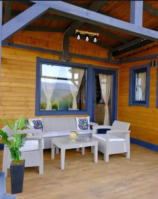 a living room with white furniture and a large window at Sapanca Balkaya Bungalov in Sapanca