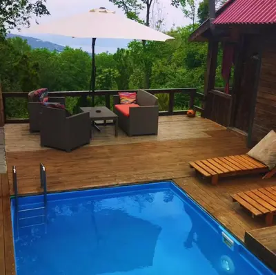 a deck with a pool and chairs and an umbrella at Sapanca Balkaya Bungalov Dağ evi in Sapanca