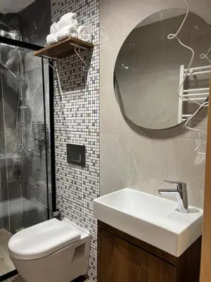 a bathroom with a sink and a toilet and a mirror at Arkeon Bosphorus Hotel & Suites in Istanbul