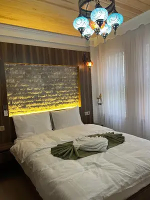 a bedroom with a large white bed with a chandelier at Arkeon Bosphorus Hotel & Suites in Istanbul