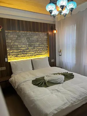 a bedroom with a large white bed with a chandelier at Arkeon Bosphorus Hotel & Suites in Istanbul