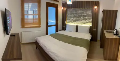 a bedroom with a bed and a desk and a television at Arkeon Bosphorus Hotel & Suites in Istanbul