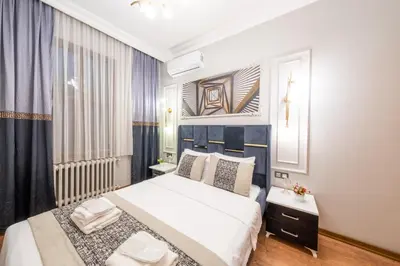 a bedroom with a large white bed and a window at King Suit Beşiktaş apart in Istanbul