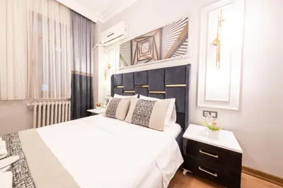 a white bedroom with a large white bed and a window at King Suit Beşiktaş apart in Istanbul