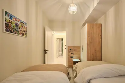 a bedroom with two beds and a chandelier at BSY's Stylish 1BR,2BR ,3BR Apartments in Brand New Building in Istanbul