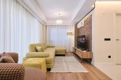 a living room with a couch and a tv at BSY's Stylish 1BR,2BR ,3BR Apartments in Brand New Building in Istanbul