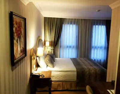a hotel room with a bed and two windows at The Central Hotel in Istanbul