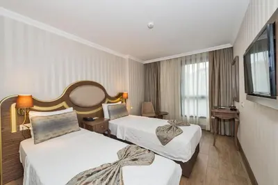 a hotel room with two beds and a flat screen tv at The Central Hotel in Istanbul