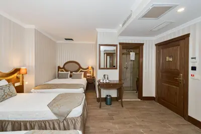 a hotel room with three beds and a bathroom at The Central Hotel in Istanbul