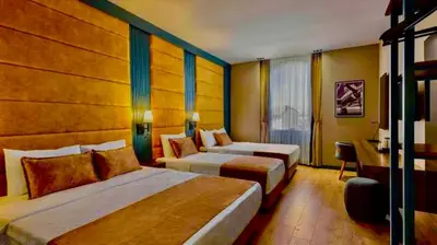 a hotel room with two beds and a desk at İSTANBUL Taksim Palece OTEL in Istanbul