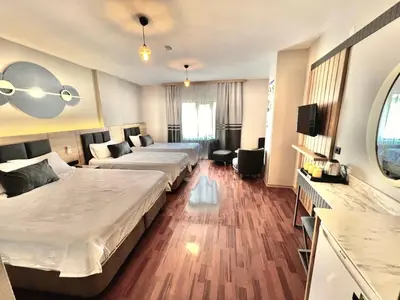 a hotel room with two beds and a couch at İSTANBUL Taksim Palece OTEL in Istanbul