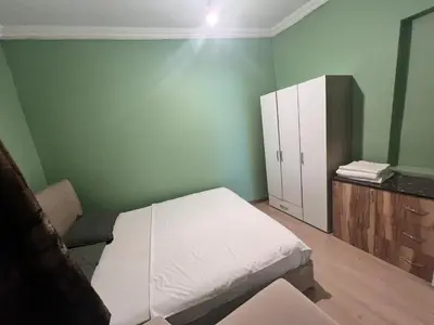 a bedroom with a white bed and a cabinet at Meryy Home in Istanbul