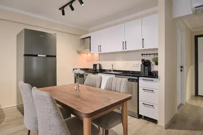 a kitchen with a wooden table and chairs and a refrigerator at House Kadıköy in Istanbul