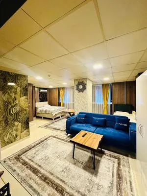 a living room with a blue couch and a bed at Nera Otel in Istanbul