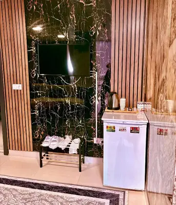 a kitchen with a refrigerator and a tv on a wall at Nera Otel in Istanbul