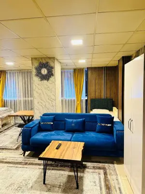 a living room with a blue couch and a bed at Nera Otel in Istanbul