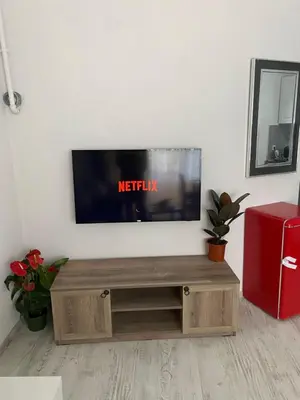 a flat screen tv sitting on top of a wooden entertainment center at ŞAH apartmanı in Istanbul