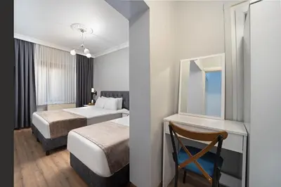 a hotel room with two beds and a mirror at Galey Pört in Istanbul