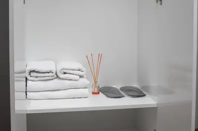 a white shelf with towels and a vase on it at Galey Pört in Istanbul