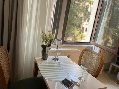 a table with two wine glasses and a vase of flowers at Şah in Istanbul