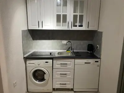 a kitchen with a sink and a washing machine at Şah in Istanbul