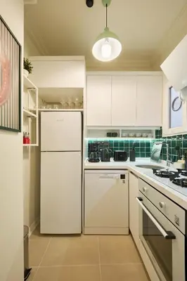 a kitchen with white cabinets and a refrigerator at Cihangir Pop Art Hideaway in Istanbul