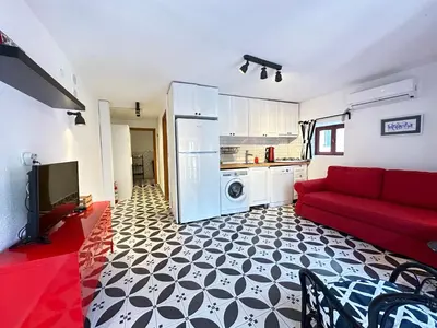 a living room with a red couch and a kitchen at Nefes Ada Taş Bina - Bahçe Katı in Istanbul