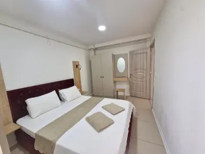 a bedroom with a large bed with white sheets at Suiton6 apart otel in İhsaniye