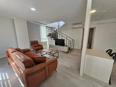 a living room with a couch and a television at Suiton6 apart otel in İhsaniye