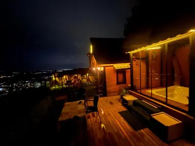 a balcony of a house at night with a tub at Sapanca Turuncu Hobbit Evi in Sapanca
