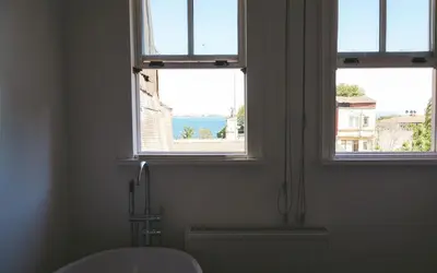 a bathroom with two windows with a view of the water at Hill House Hostel in Istanbul