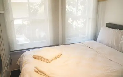a white bed with two windows in a room at Hill House Hostel in Istanbul