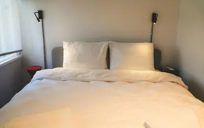 a bed with white sheets and pillows in a room at Hill House Hostel in Istanbul