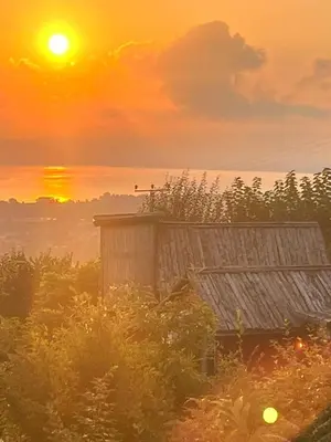 an old barn with the sunset in the background at Sapanca Kırmızı Hobbit Evi in Sapanca