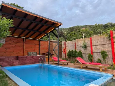 a swimming pool with a pergola next to a house at Sapanca Kırmızı Hobbit Evi in Sapanca