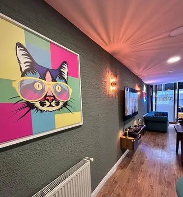 a room with a painting of a cat wearing glasses at The İstanbul Levent Çakra Palace in Istanbul