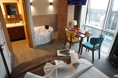 a bathroom with a tub and a table with chairs at The İstanbul Levent Çakra Palace in Istanbul