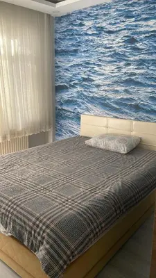 a bed in a room with a painting of the ocean at Apart house in Istanbul