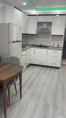 a kitchen with white cabinets and a wooden table at Apart house in Istanbul