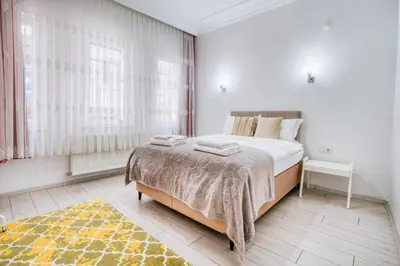a white bedroom with a large bed and a window at HANLAR Apart in Istanbul