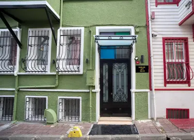 a green house with a black door and windows at HANLAR Apart in Istanbul