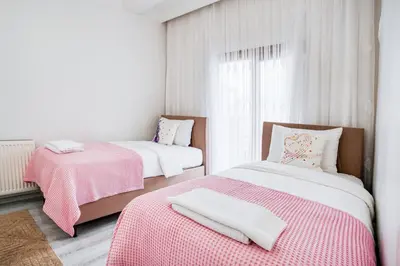 two beds in a room with pink and white sheets at HANLAR Apart in Istanbul