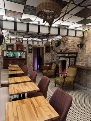 a restaurant with wooden tables and chairs and a fireplace at Veva flats hotel in Istanbul