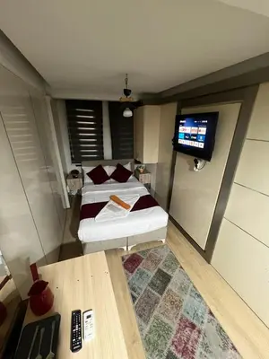 a small room with a bed and a tv at Taksim Pera Premium Gold Hotel in Istanbul